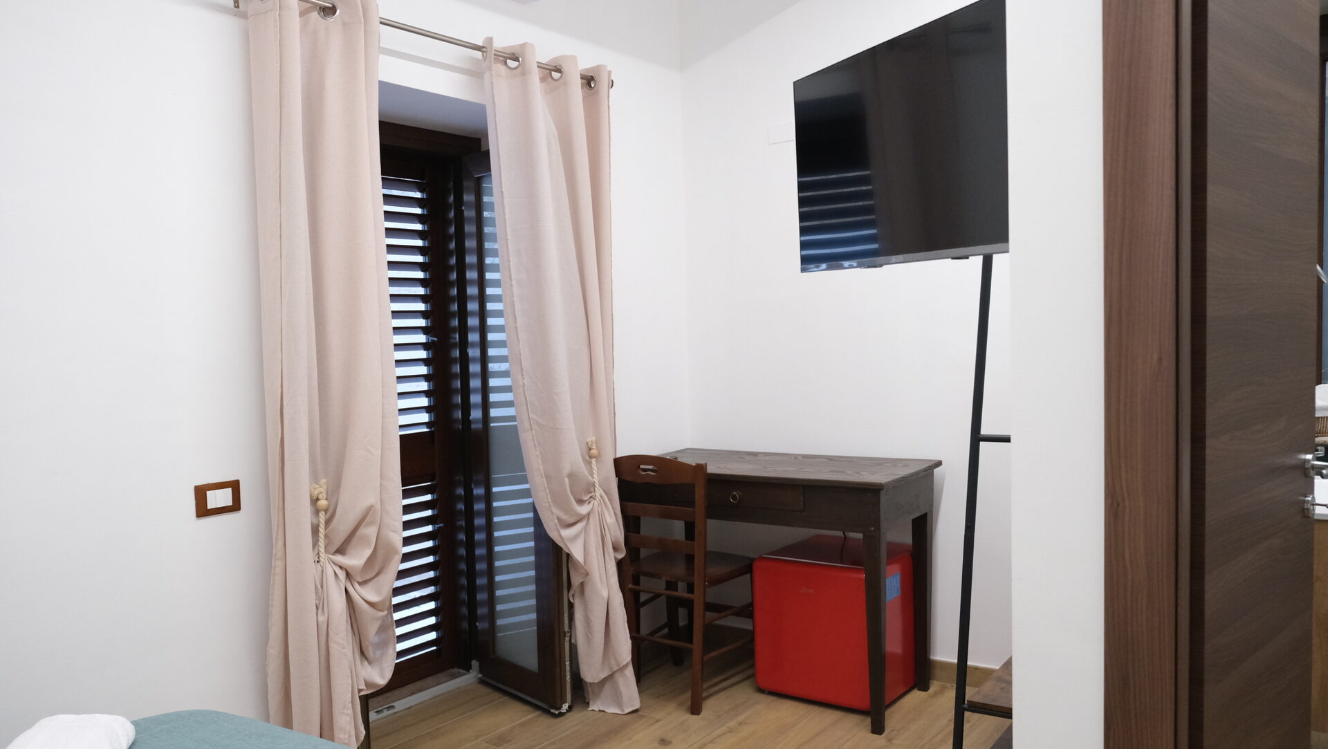 Finestra con tende e smart TV a muro